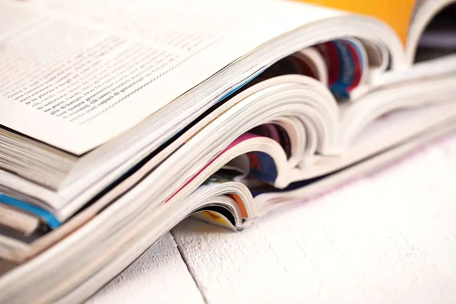Pile of colorful magazines on a white table